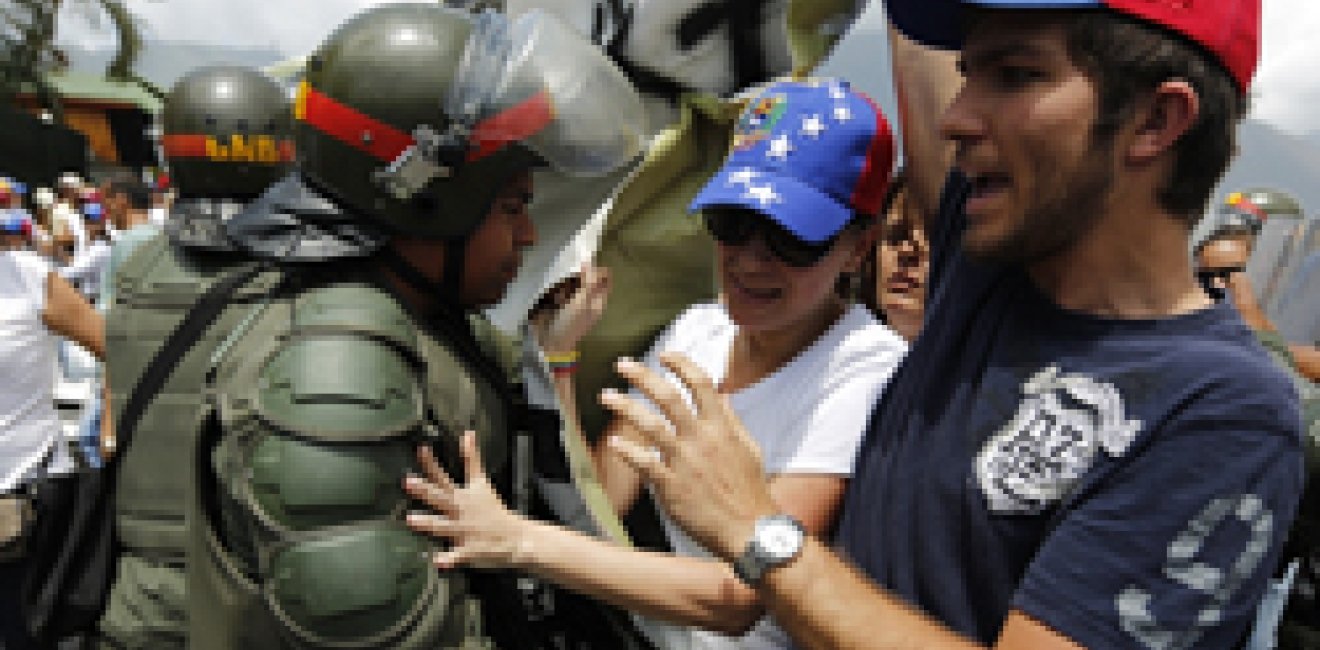 Anti-government protesters scuffle with national guards as they march by Generalisimo Francisco de Miranda Airbase in Caracas March 4, 2014. 