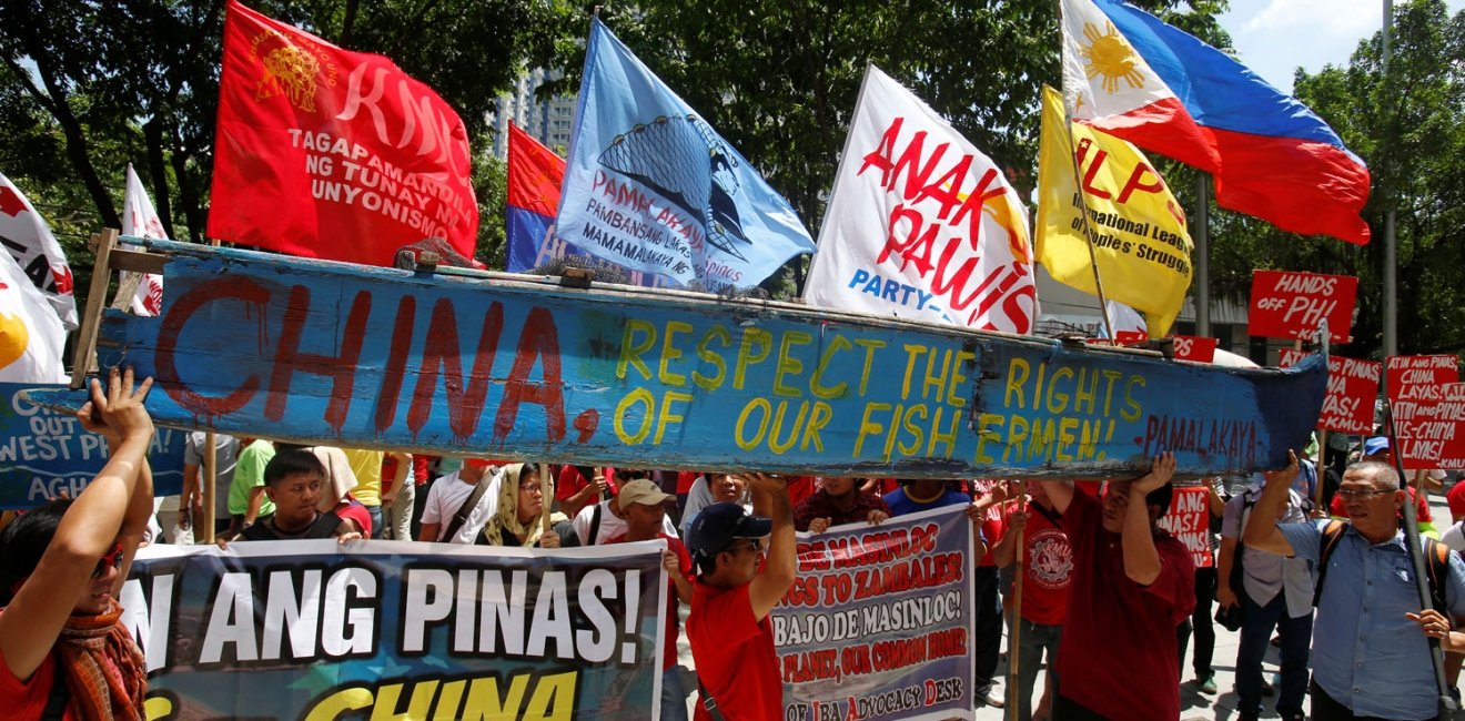 Demonstrators display a part of a fishing boat with anti-China protest signs during a rally by different activist groups over the South China Sea disputes, outside the Chinese Consulate in Makati City, Metro Manila, Philippines 