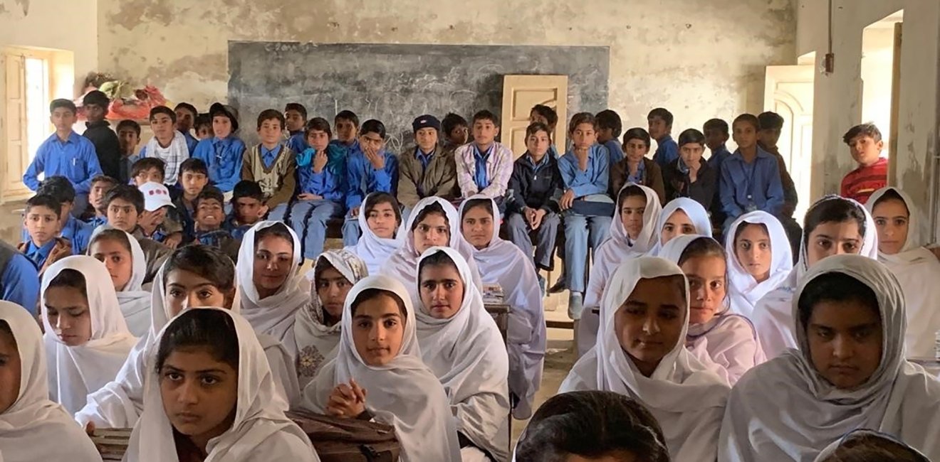 Pakistani children packed into an overcrowded schoolroom.