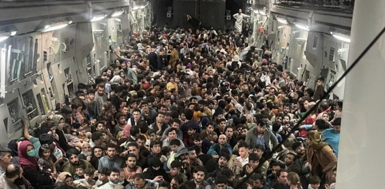 Hundreds of Afghan citizens crowd across the floor of an American military airplane.