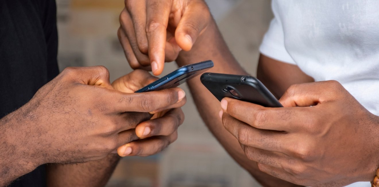 Hands holding phones and pointing