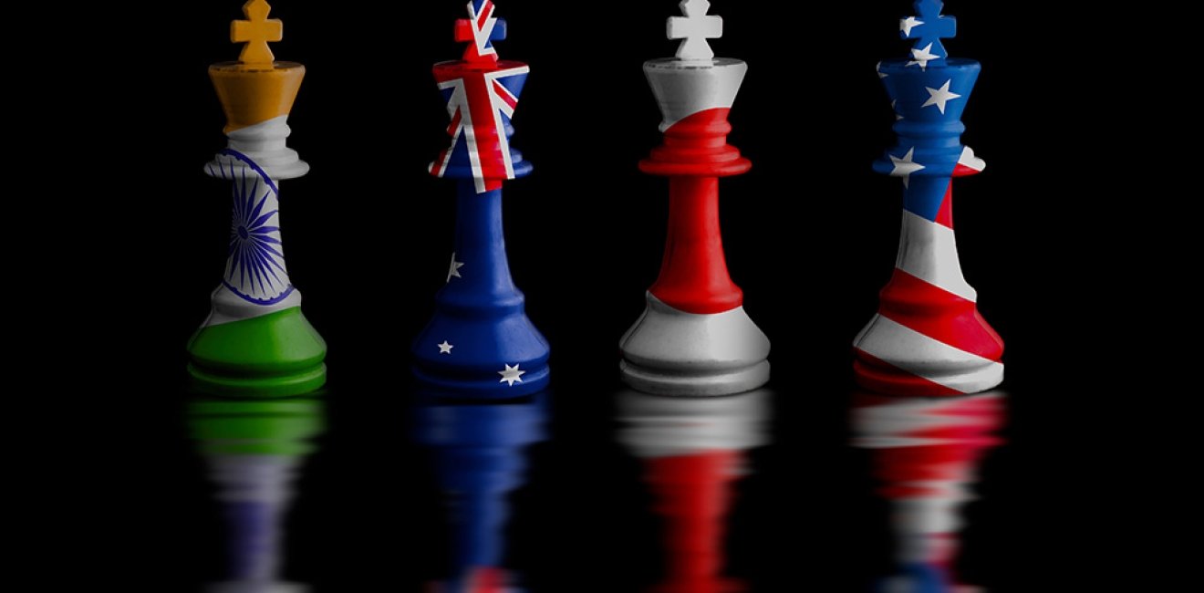 Four chess rooks with the flags of India, Australia, Japan, and the United States imprinted on them.