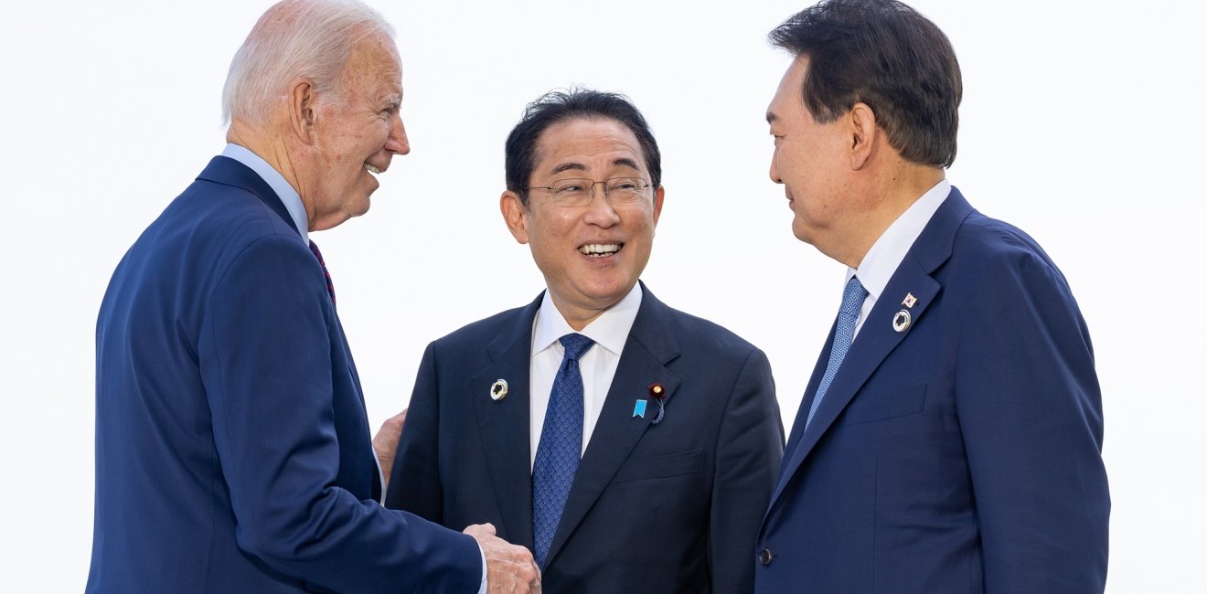 President Biden, Prime Minister Kishida, and President Yoon speaking casually at an event.