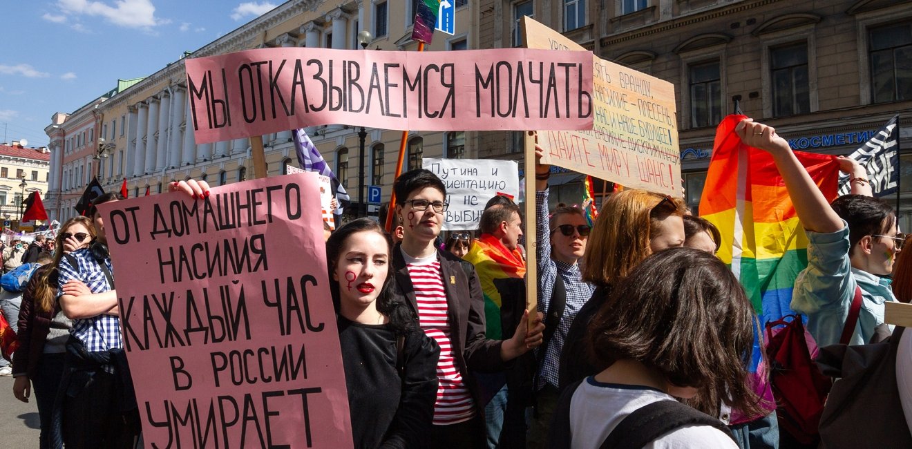 Protesters with the poster "One woman dies every hour of domestic violence in Russia."