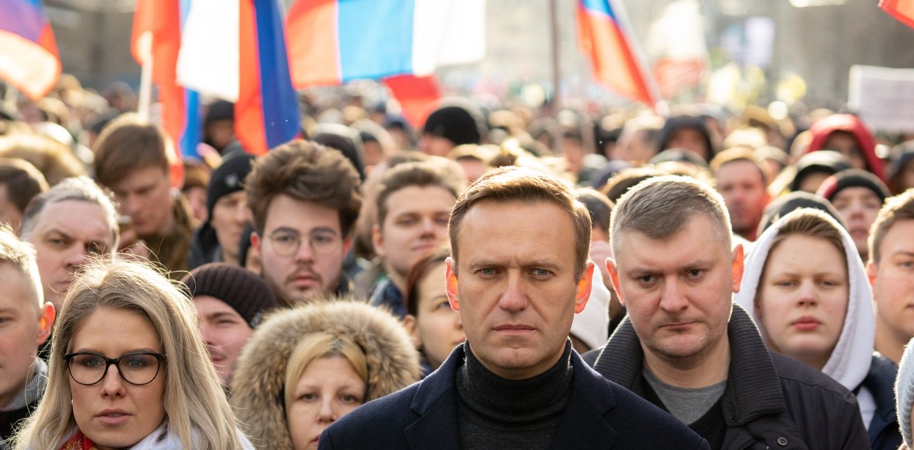 Lyubov Sobol abd Alexei Navalny on march in memory of Boris Nemtsov. People, flag and poster on the background, February 2020.