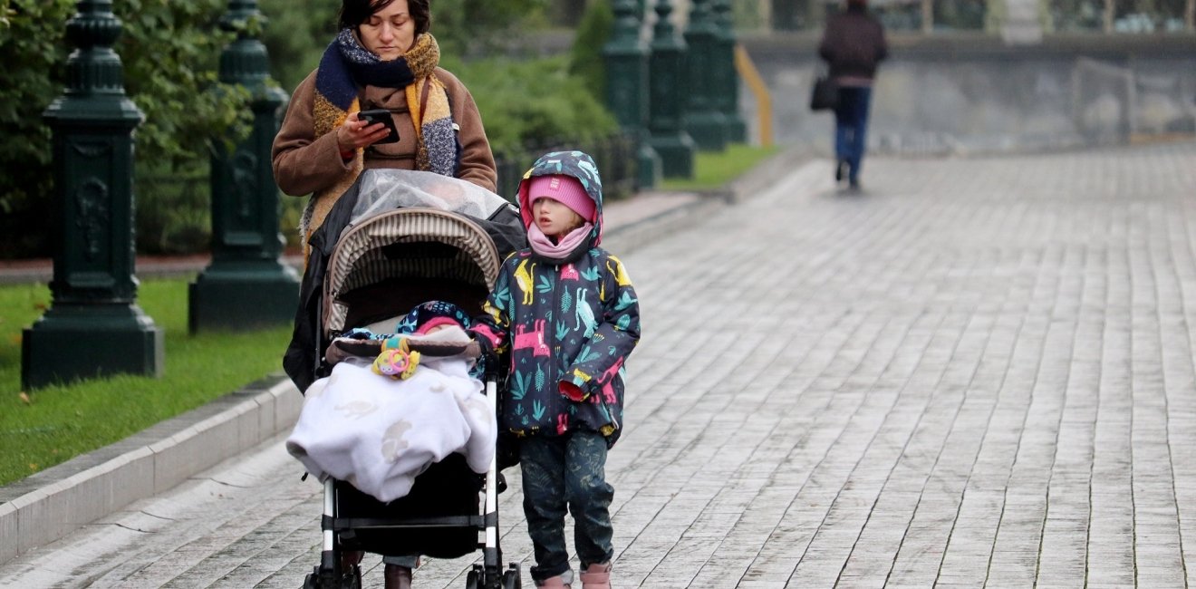 A mother and child walk down the street in Russia, October 2020