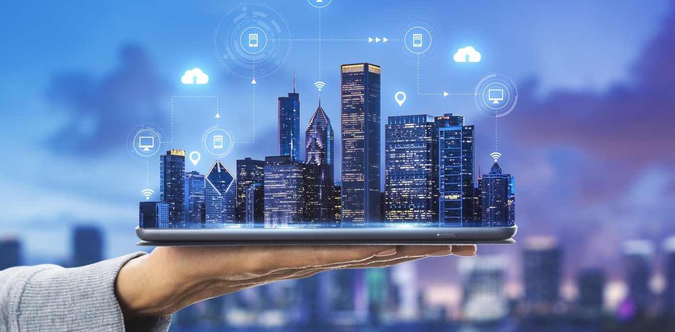 Smart city technologies concept with digital tablet and night megapolis city skyscrapers with digital cloud icons on human hand at blurry skyline background