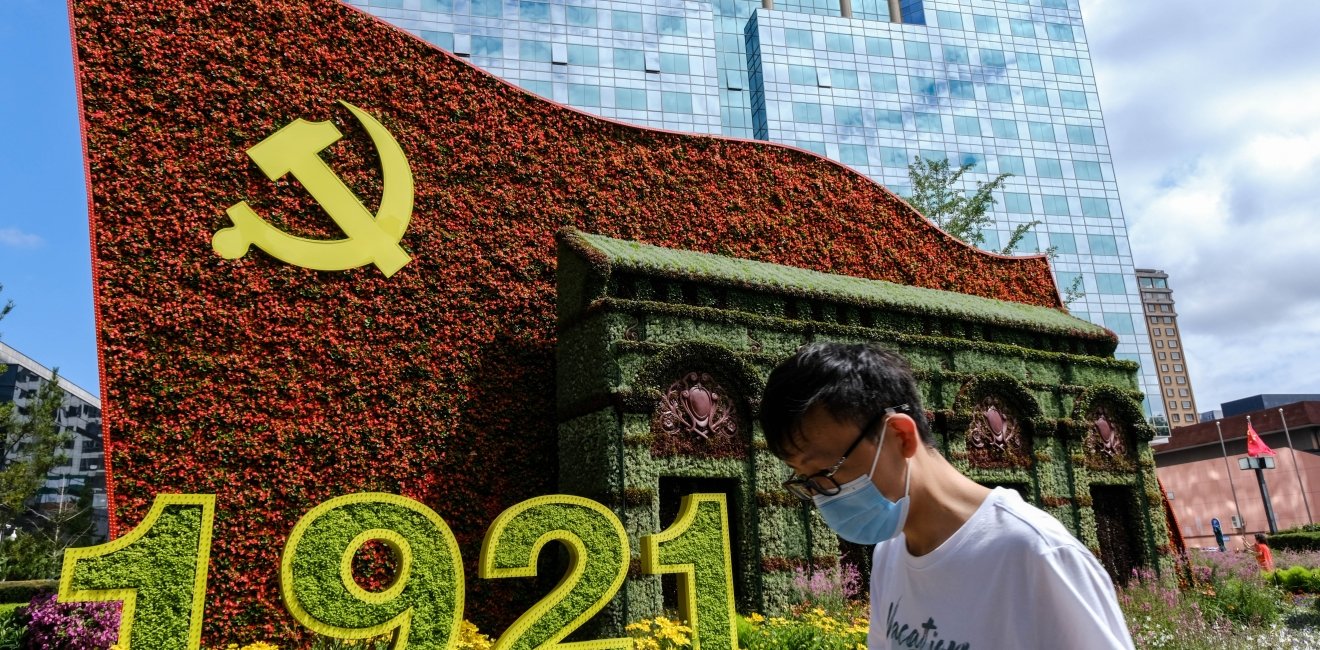 Beijing China - July 3 2021: A man walks in front of a display marking the centennial anniversary of the Communist Party of China (CPC) 