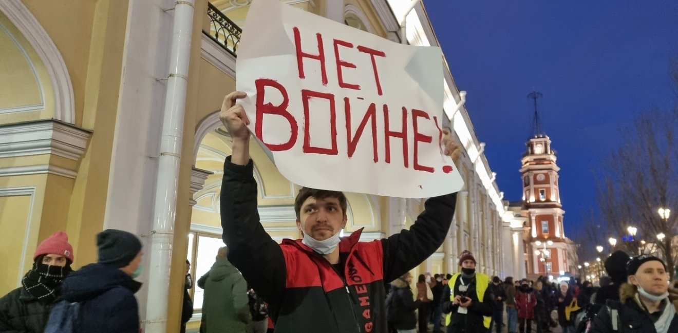 Man holding sign with Russian text declaring "No War" 