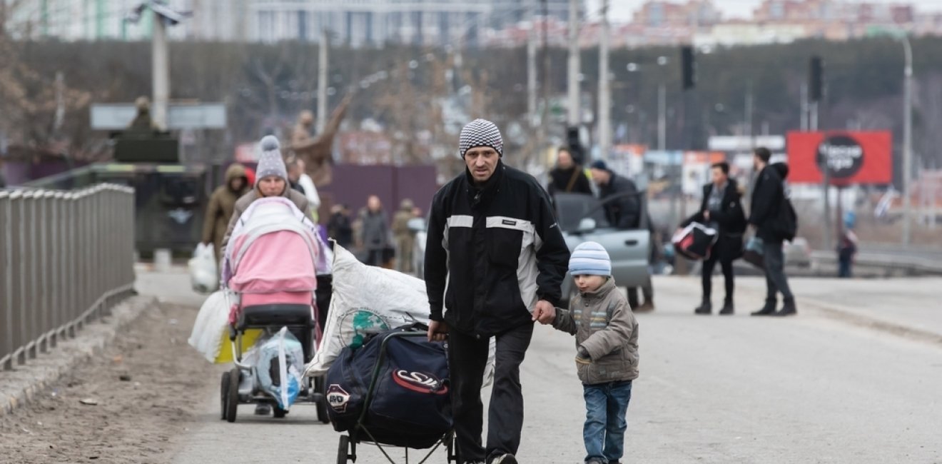 Group with children carrying items down a road