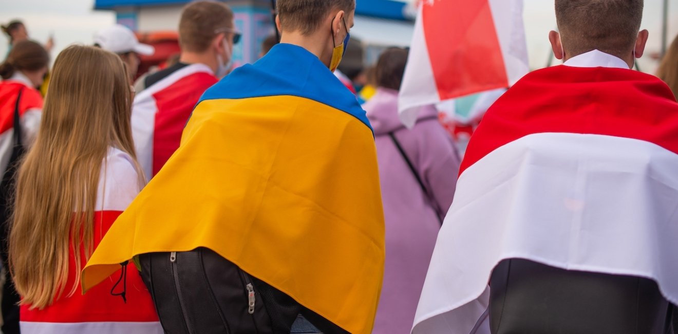 A group of protesters holding Ukrainian and Belorusian white and red flag