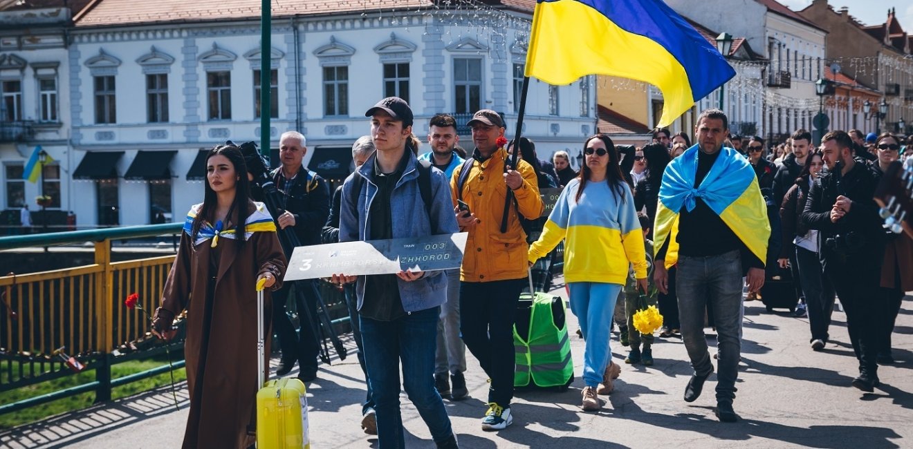 Protesters walking down street with Ukrainian Flags