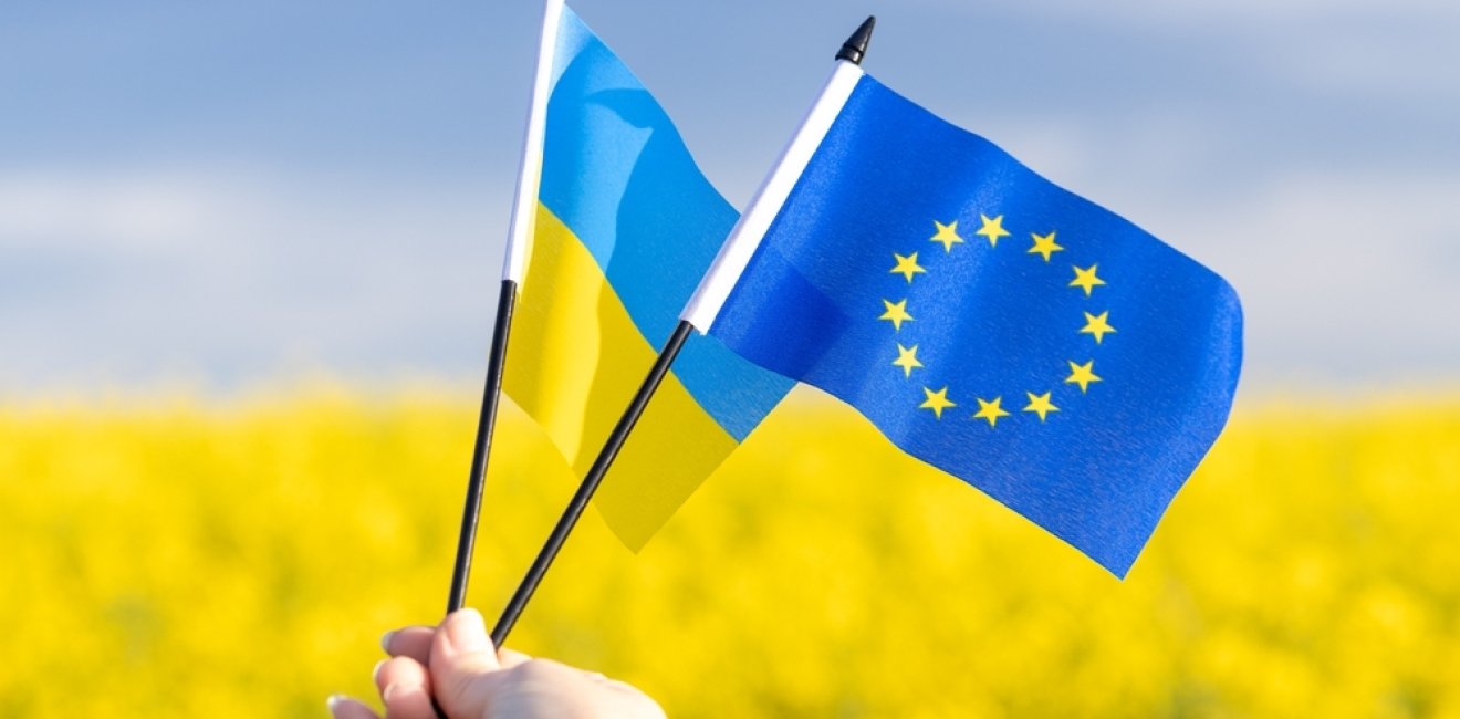 Flags with symbols of the European Union and Ukraine held in a girl's hand, Concept, Acceptance of the Ukrainian candidacy to apply for EU membership