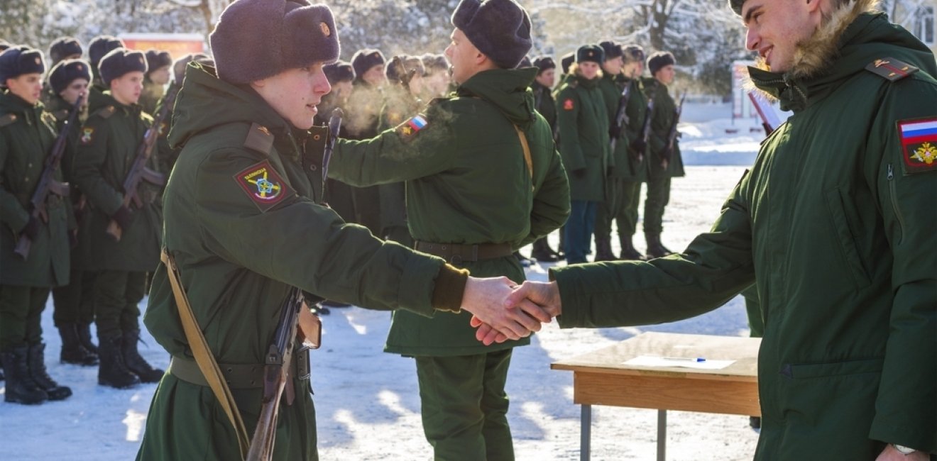 young soldier shakes hand of military recruitment officer