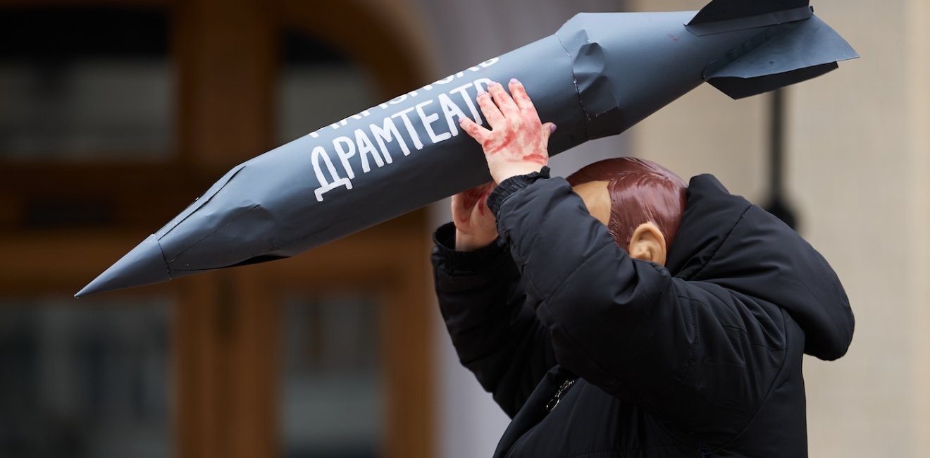 Actor in mask of vladimir putin attacks civilians with the rocket during the art performance dedicated to the anniversary of russian airstrike on Mariupol Drama Theatre in 2022.