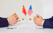 Flags of America and China stand on table during talks between diplomats