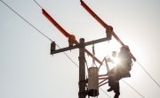 Lineman electrician engineer working climbing a pole to repair and maintain a power line and a transformer