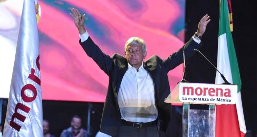 AMLO with his hands up at a Morena rally