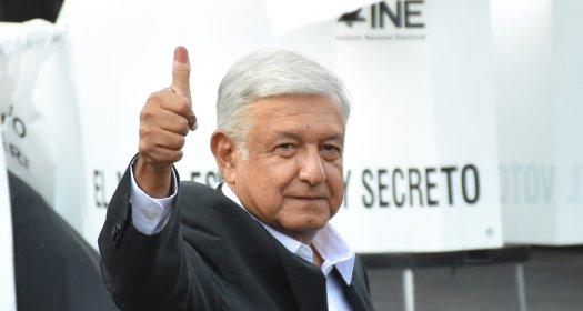 AMLO gives a thumbs up with his ink-stained finger.