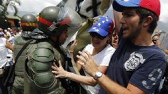 Anti-government protesters scuffle with national guards as they march by Generalisimo Francisco de Miranda Airbase in Caracas March 4, 2014. 