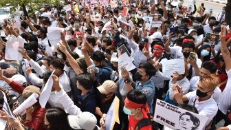 A group of people gather for a protest, many holding signs saying We Want Our Leader Free.