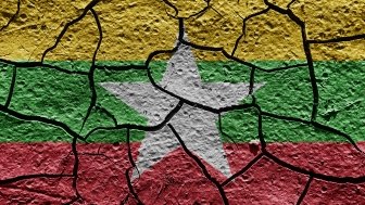 The flag of Myanmar painted on cracked pavement