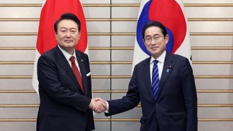 South Korean President Yoon and Japanese Prime Minister Kishida shaking hands in a photo op.