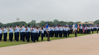 Airmen salute an American flag