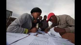 A South African submitting their vote 