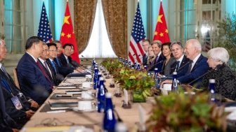 Delegations sit on opposite sides of a long conference table, President Xi on the left side and President Biden on the right.