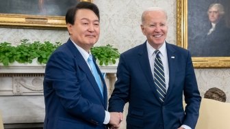 President Yoon shakes hands with President Biden in the Oval Office.