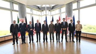 A group of world leaders posing in front of their respective flags at the G7 Summit in Hiroshima.