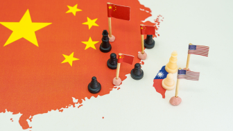 Chess pawns representing China on one side and the US on the side of a map of Taiwan