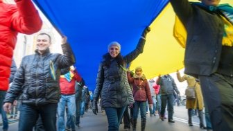 Street protestors hold a giant Ukrainian flag