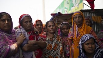 Bangladeshi women stand together outside.