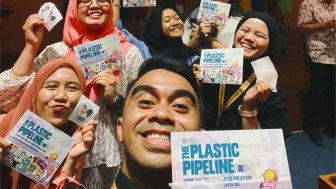 Indonesian students and educators taking a selfie with the plastic pipeline brochures and sticker