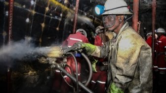 Chrome and Platinum miners drill holes to place dynamite in a mine in northeastern South Africa