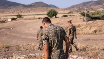 Nagorno-Karabakh, Republic of Artsakh - 08/03/2019 - Three soldiers of the Artsakh Defense Army walking on dirt road in their off time