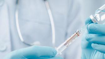 octor or scientist in laboratory holding a syringe with liquid vaccines for children or older adults