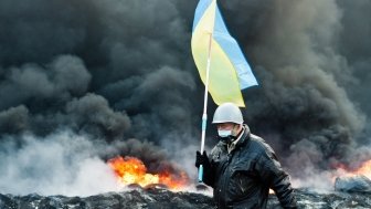 Unknown demonstrator carrying a Ukrainian flag at the Independence square in Kyiv during Euromaidan