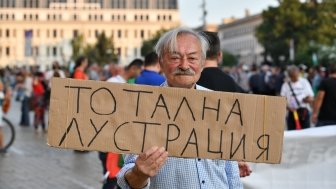 Man holding protest sign in Sofia, Bulgaria