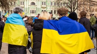 Ukrainian flag draped over peoples' backs