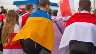 A group of protesters holding Ukrainian and Belorusian white and red flag