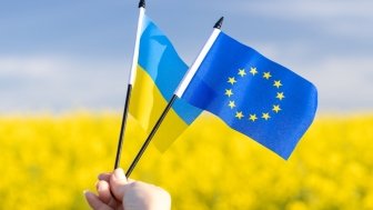 Flags with symbols of the European Union and Ukraine held in a girl's hand, Concept, Acceptance of the Ukrainian candidacy to apply for EU membership