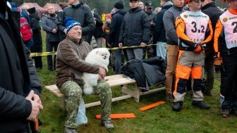 President Lukashenko sitting with a small white dog among a crowd of people 