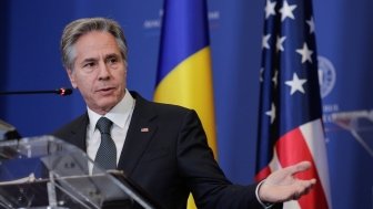 Secretary Blinken in front of Ukrainian and US flags