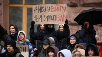 Young Ukrainian activists show a banner "I Live In A War Because of Someone's New Villa" on a protest against corruption in Ukraine