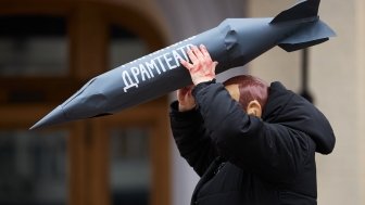 Actor in mask of vladimir putin attacks civilians with the rocket during the art performance dedicated to the anniversary of russian airstrike on Mariupol Drama Theatre in 2022.