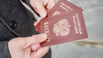 Two russian passports in hand. Russian official document on outdoor background