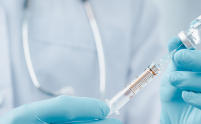 octor or scientist in laboratory holding a syringe with liquid vaccines for children or older adults